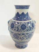 A large Chinese blue and white porcelain vase with stylised floral design and ring handles. Qianlong