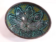 An Islamic ceramic glazed bowl with stylised floral design. Signature to base. 17cm