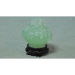 A 20th century serpentine jade lidded censer on a footed pierced carved hardwood base. The censer is