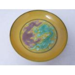 A Kangxi style porcelain golden-yellow ground Dragon dish, six-character Guangxu mark. Grape