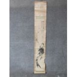 A Chinese ink on paper mounted scroll depicting bamboo with calligraphy and red artists seal mark.