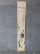 A Chinese ink on paper mounted scroll depicting bamboo with calligraphy and red artists seal mark.