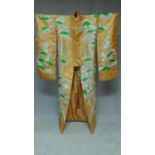 A Japanese orange fabric metallic embroidered kimono, decorated with flowers, bridges and stylised