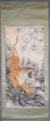 A Japanese mounted scroll, ink and watercolour on paper, a snarling tiger against a naturalistic