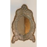 A 19th century Ottoman repoussé white metal framed wall mirror, wooden backed, silver decorated with