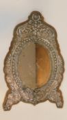 A 19th century Ottoman repoussé white metal framed wall mirror, wooden backed, silver decorated with