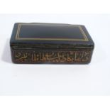 A 19th century Qajar lacquer snuff box decorated with calligraphy and a linear border to the top.