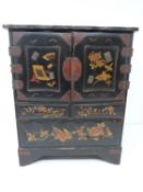 An early 20th century Japanese gilded lacquer table top cabinet with drawers decorated with flower
