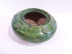 An early Islamic green glazed pottery circular lantern, decorated with floral motifs. d8cm