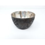 A Chinese carved coconut shell silver lined wine cup. Makers stamp to the inside. Decorated with