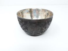 A Chinese carved coconut shell silver lined wine cup. Makers stamp to the inside. Decorated with