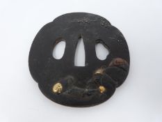 A 19th century Shibuchi bronze Tsuba with gilded details. It depicts on one side a rock with a fence