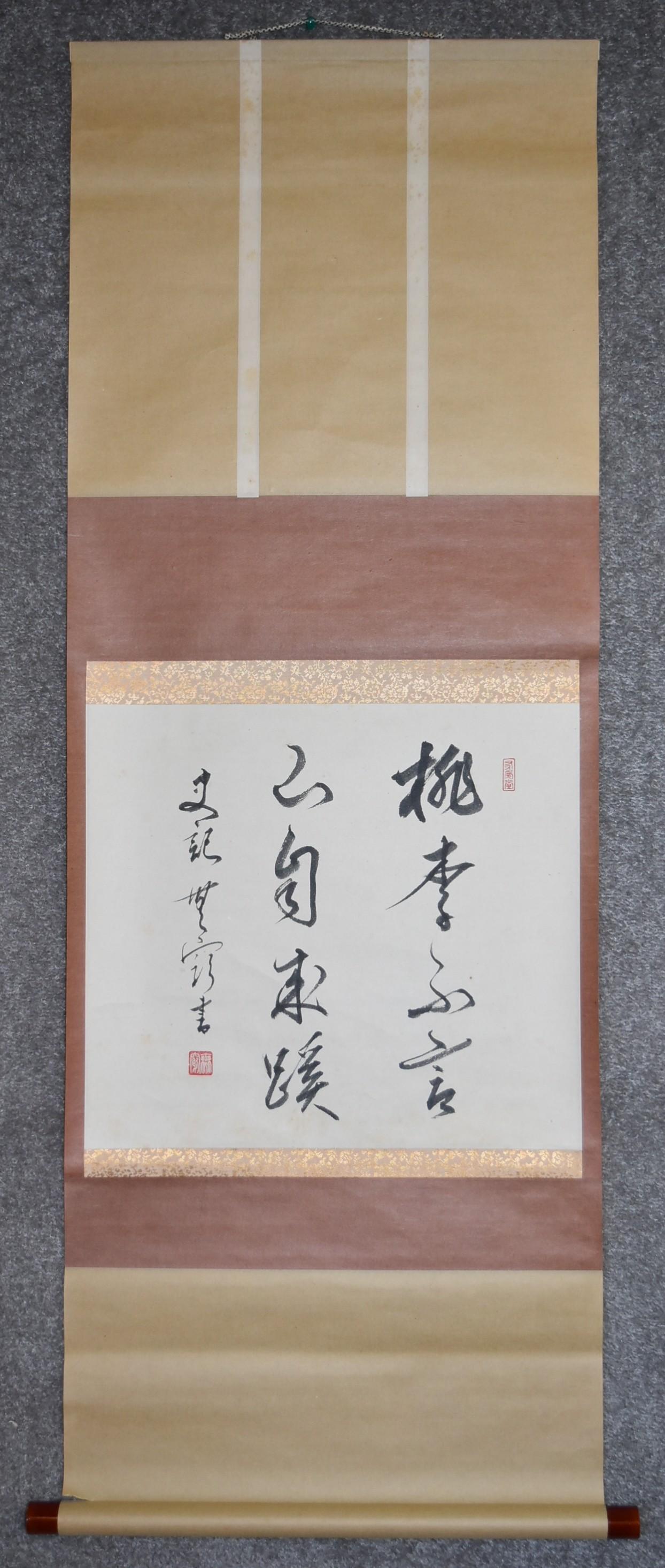 A Japanese mounted scroll, ink on paper, calligraphy within a floral silk border, signed. L.116x42cm