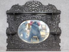 A Qing dynasty intricately carved Chinese hardwood wall mirror with dragon motifs and three