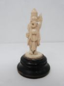 A 19th century ivory carved statue of Ganesha the Indian god mounted on a circular ebonised base.