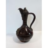 A 19th century Turkish Çanakkale brown glaze pottery ewer with applied medallions and scroll