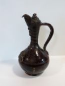 A 19th century Turkish Çanakkale brown glaze pottery ewer with applied medallions and scroll