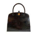 A Hermes Dalvy in black shiny crocodile with gold hardware and orange dustbag. W.30 x H.23 x D.10cm,