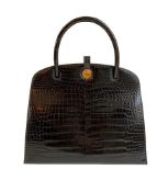 A Hermes Dalvy in black shiny crocodile with gold hardware and orange dustbag. W.30 x H.23 x D.10cm,