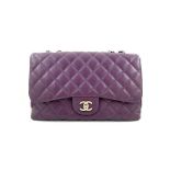 A Chanel Classic Flap Bag Jumbo in Purple Caviar with Silver Hardware, is instantly recognizable