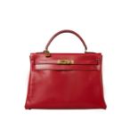 A red Hermes Kelly in tadelakt leather with gold hardware. W.32cm x H.23cm x D.10.5cm, stamped O (