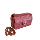 A Chanel Classic Flap in Dusky Pink Crocodile leather with Gold Hardware is instantly recognizable