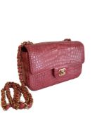 A Chanel Classic Flap in Dusky Pink Crocodile leather with Gold Hardware is instantly recognizable