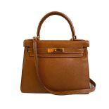 A gold Hermes Kelly in Courcheval leather with gold hardware, including Strap, Key, Lock and