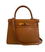 A gold Hermes Kelly in Courcheval leather with gold hardware, including Strap, Key, Lock and