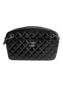 A Chanel Classic Camera Case in Black Lambskin with Silver Hardware, takes design inspiration from