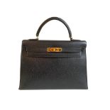 A black Hermes Kelly in Evergrain leather with gold hardware, includes Dustbag, Key (no lock),