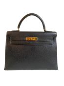 A black Hermes Kelly in Evergrain leather with gold hardware, includes Dustbag, Key (no lock),