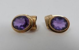 A pair of oval 18 carat yellow gold and amethyst stud earrings. Each set with an oval mixed cut