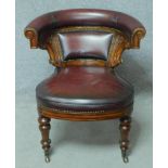 A 19th century mahogany framed desk chair with deep burgundy leather upholstered hooped back and