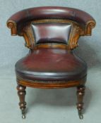 A 19th century mahogany framed desk chair with deep burgundy leather upholstered hooped back and