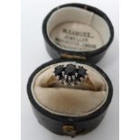 A vintage three stone sapphire and diamond ring in an antique leather effect ring box. Set with