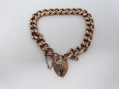 A 9ct rose gold curb link antique charm bracelet. Every other link is engraved and it fastens with a