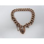 A 9ct rose gold curb link antique charm bracelet. Every other link is engraved and it fastens with a