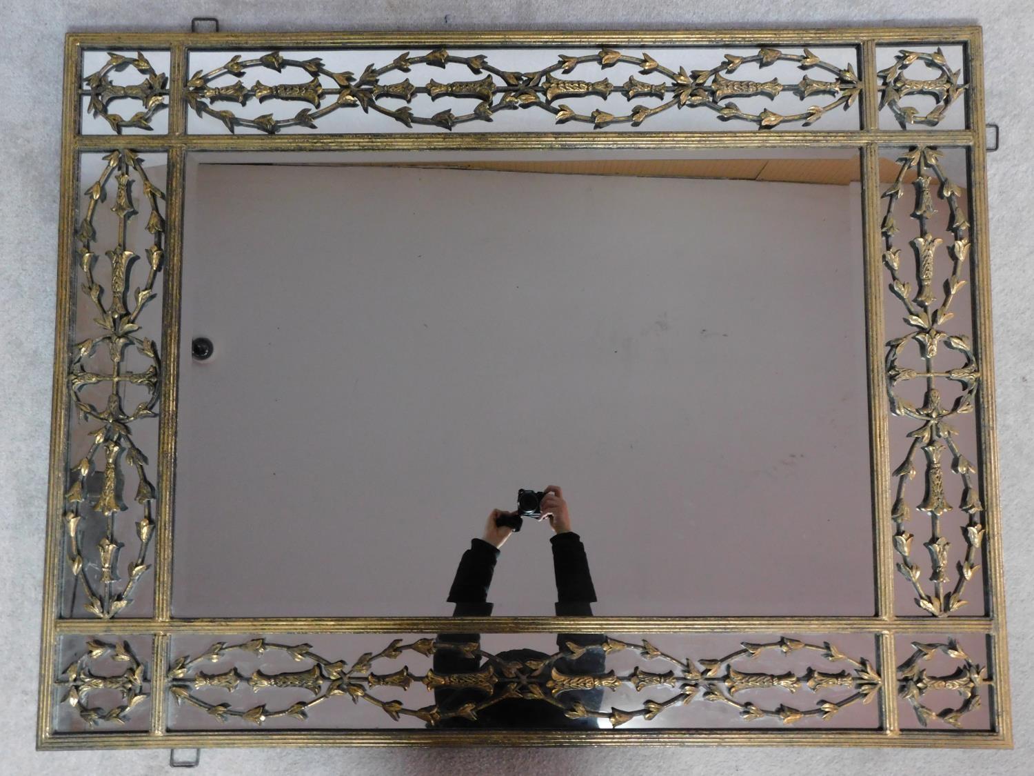 A large contemporary gilt metal overmantle or wall mirror the central rectangular plate surrounded