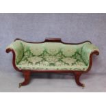 A small Regency mahogany framed scroll arm sofa in newly upholstered emerald floral damask raised on