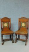 A pair of oak Arts and Crafts hall chairs with carved backs and solid seats on turned stretchered