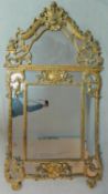 An antique French carved giltwood Rococo style pier mirror with allover scrolling foliate detail and