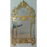 An antique French carved giltwood Rococo style pier mirror with allover scrolling foliate detail and