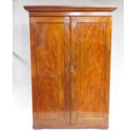 An early 19th century figured mahogany wardrobe with stepped moulded pediment above panel doors