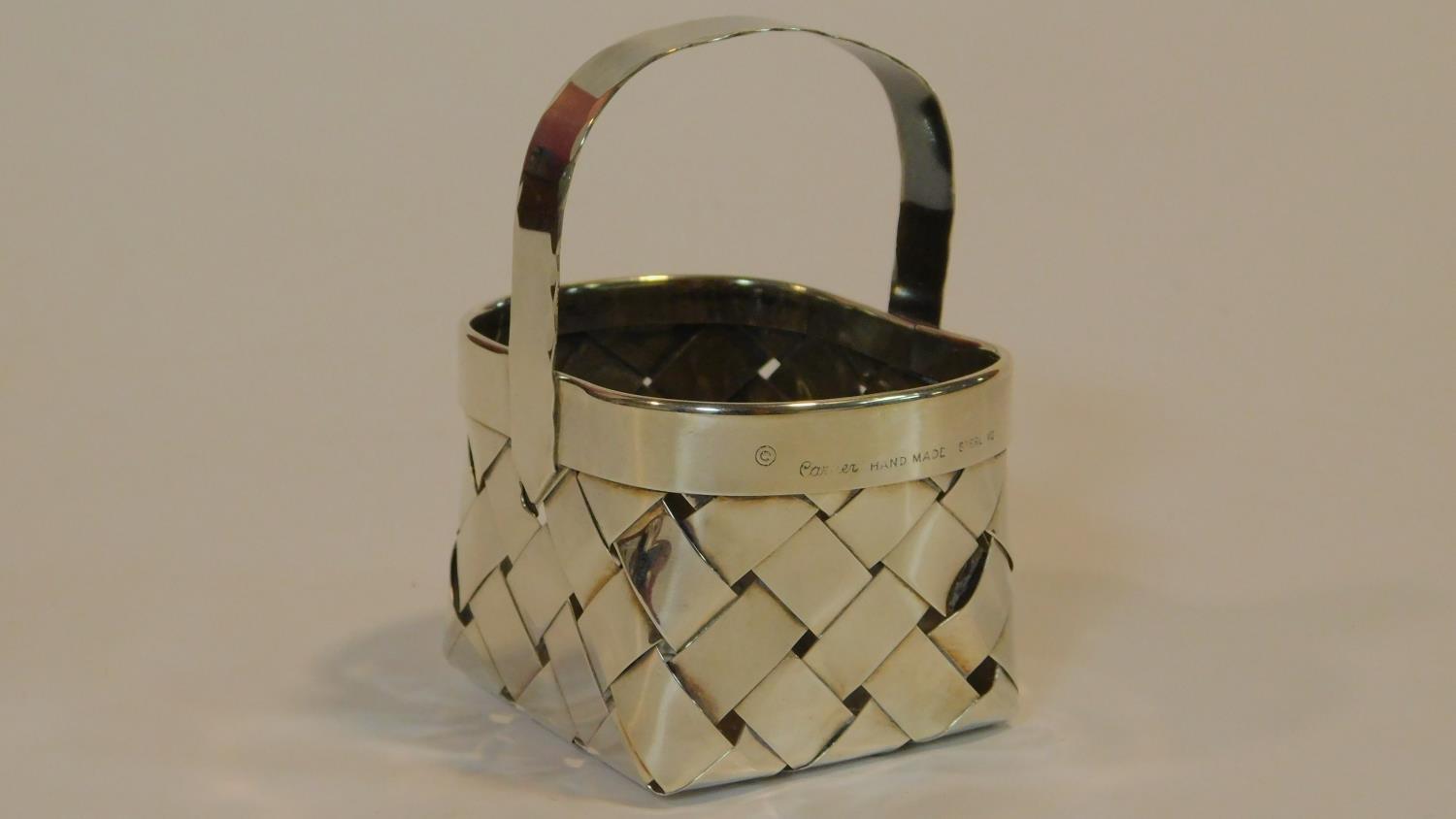 A Cartier silver basket of oval woven form with a scalloped edged handle, end marked to the side