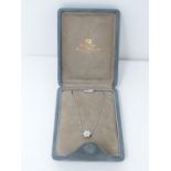 A suede cased 18 carat white gold and diamond floral pendant and chain by Mappin & Webb. Set with