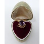 An antique 9 ct yellow gold and amethyst dress ring in a heart shaped vintage ring box. Set with