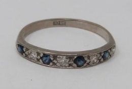 An 18ct white gold, sapphire and diamond half eternity ring. Set with four round mixed cut sapphires