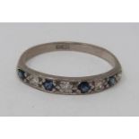 An 18ct white gold, sapphire and diamond half eternity ring. Set with four round mixed cut sapphires