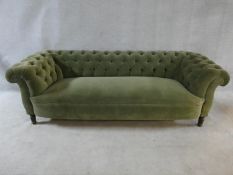 A late 19th century buttoned back Chesterfield sofa upholstered in pale green on turned tapering